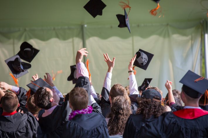 graduate students tossing hats proud of their student achievement and educational outcomes